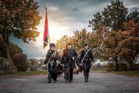 Mitglieder des Vereins in schwarzen Uniformen bei einem Auftritt